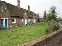 The Alms Houses, Roydon Road. Founded in 1635 by Sir Edward Baesh, who was a resident of the village; he left six almshouses for widows and decayed tradesmen. Although there are six doors the number of dwellings has been reduced. Photo 2006.