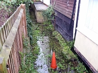 I don't know the origins of this stream, if indeed it is a stream, but it is directly behind the phone box in the High Street. This is where the Hot Food sign finished up. Photo 2010.