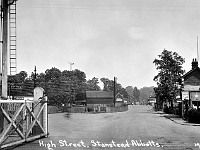 High Street fom the level crossing. Date unknown. Station Garage on the right. Any details welcome. Postcard unmarked